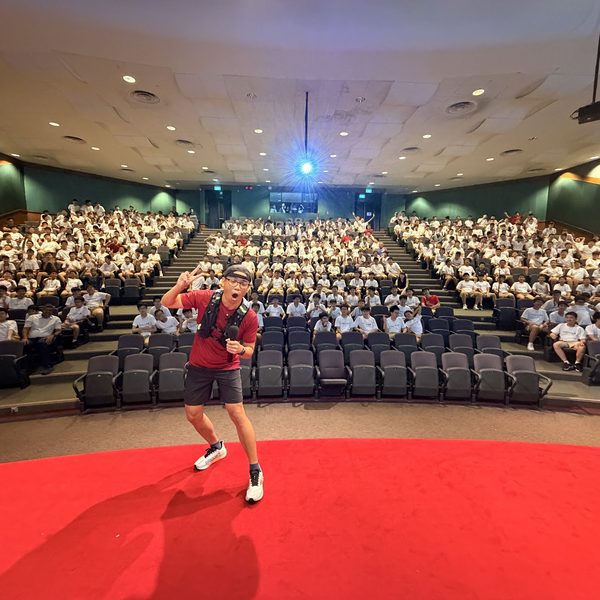 Kao speaking on stage to a school audience in Singapore